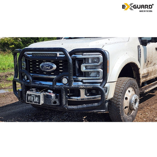 White Ford F-450 truck with an Ex-Guard Grille Guard front bumper on a dirt road