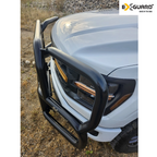 White Ford F-150 truck with a black Ex-Guard Grille guard or bumper on a gravel surface.