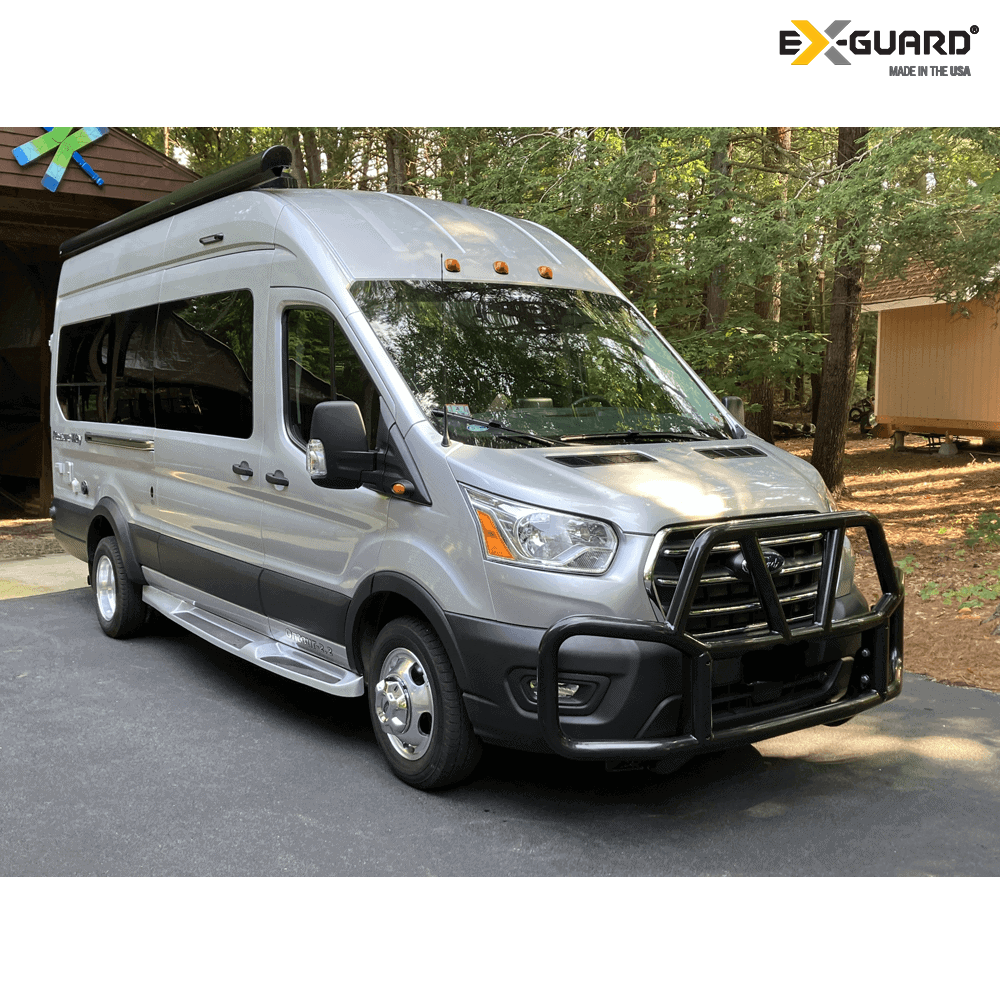 Silver van with roof rack in a wooded area